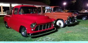 Classic trucks at a car show at night